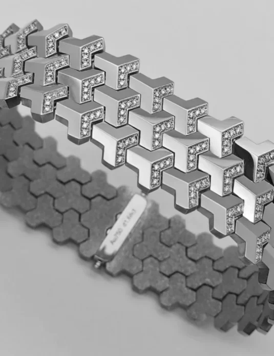 Bracelet en or blanc serti de diamants pavés, orné d'un motif géométrique inspiré des armures et composé de segments imbriqués