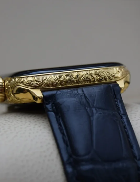 Apple Watch grabado en oro con intrincados motivos ornamentales en caja de oro de 24 quilates y correa de piel de cocodrilo azul