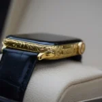 Apple Watch grabado en oro con intrincados motivos ornamentales en caja de oro de 24 quilates y correa de piel de cocodrilo azul marino