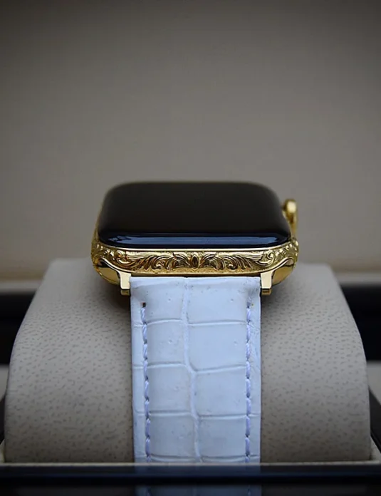 Apple Watch aus 24-karätigem Gold mit kunstvollen barocken Rankenmustern auf Gehäuse und Krone