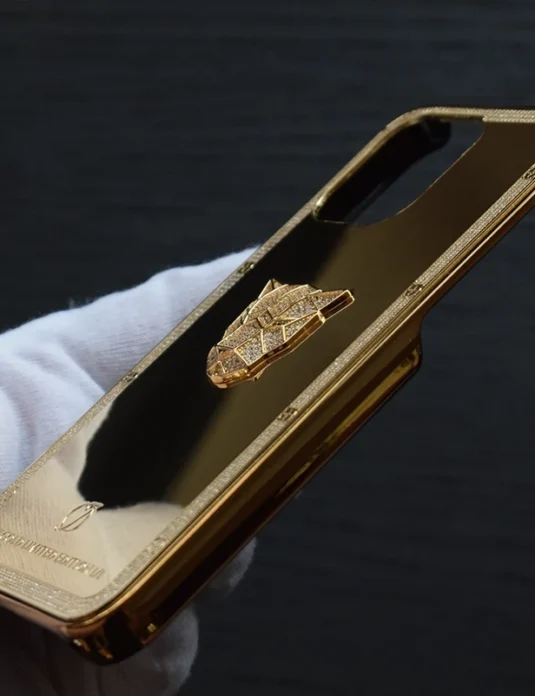 24k gold iPhone case panther edition with gold plated bumper and panther emblem held in white gloved hands