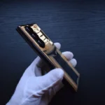 金色三星折叠手机，白色手套握持，展示24K镀金表面和可折叠设计