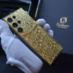 Goldene Samsung S25 Ultra 3D-Gravur mit kunstvollem Barockmuster, gehalten in einer weiß behandschuhten Hand