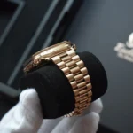 Apple Watch Ultra en or rose plaqué or 24 carats, tenue dans des mains gantées de blanc