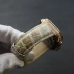 玫瑰金钻石Apple Watch Ultra配香槟鳄鱼皮表带，白手套握持