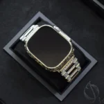 Apple Watch Ultra en or blanc gravée de motifs baroques ornementaux, présentée dans un luxueux coffret