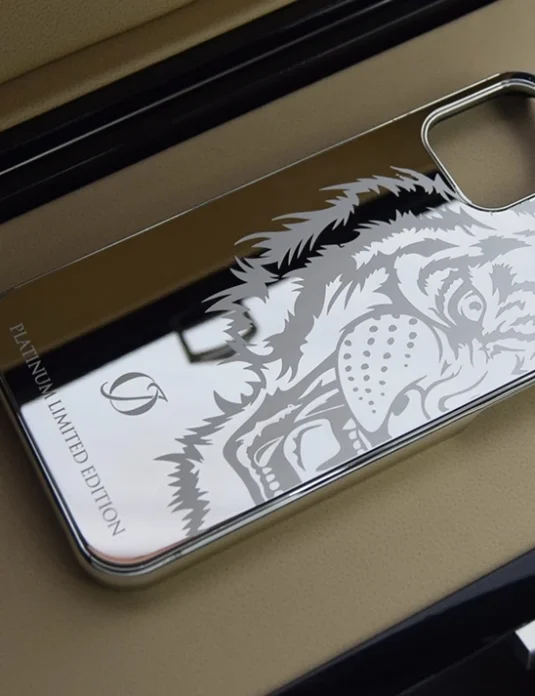 White gold iPhone case bumper with laser-engraved wolf design and 24k plating displayed on black surface