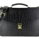 Black alligator briefcase with gold hardware and shoulder strap showing distinctive scale texture