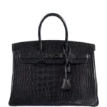 Black alligator handbag Birkin style with crocodilian leather texture and gold hardware