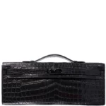 Black crocodile leather clutch with Kelly Cut design and handle, showing scaled texture and elegant profile
