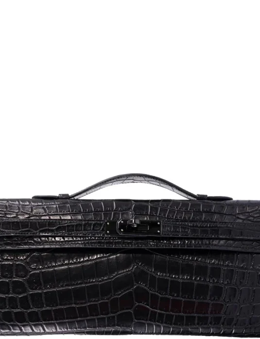 Black crocodile leather clutch with Kelly Cut design and handle, showing scaled texture and elegant profile