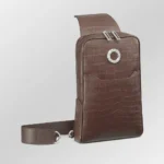 Brown crocodile sling bag with textured leather finish and adjustable strap shown from front angle