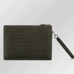 棕色鳄鱼皮手提包，表面磨砂处理，配有可拆卸腕带，置于中性背景上