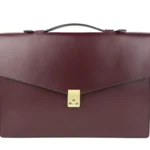 Burgunderrote Lederaktentasche mit goldenem Schlossverschluss und schwarzem Ledergriff, von vorne gesehen