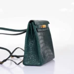 Green crocodile backpack Kelly Ado showing scaled leather texture and gold hardware details