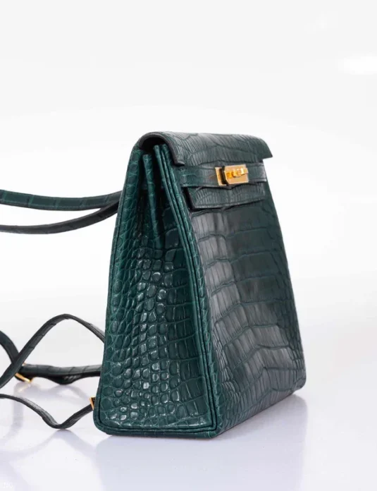 Green crocodile backpack Kelly Ado showing scaled leather texture and gold hardware details