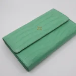 Light green crocodile clutch with envelope design showing crocodile leather texture and gold hardware