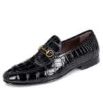 Black alligator leather loafers with gold bit detail showing distinctive scaling pattern and glossy finish