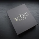 Luxury packaging box in charcoal grey with gold foil branding on dark wood surface