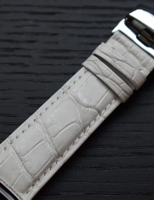 Apple Watch de platino con diamantes, correa de piel de cocodrilo blanca con escamas texturizadas y caja pulida