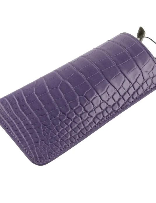 Purple crocodile glasses case showing scaled leather texture and metal pull-tab detail