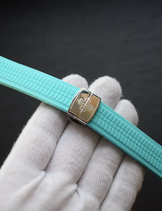 Tiffany blue rubber apple watch band with textured pattern and gold hardware held in white gloved hand