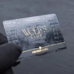 Black leather membership card with crocodile texture and gold foil lettering for The Wolfs Club authentication