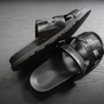 صنادل جلد تمساح أسود مع أشرطة جلد تمساح منقوشة ونعل مكوَّن