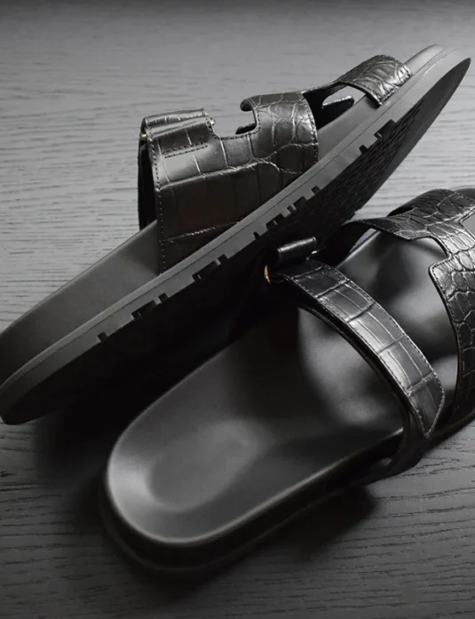 صنادل جلد تمساح أسود مع أشرطة جلد تمساح منقوشة ونعل مكوَّن