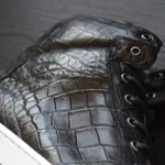 Black crocodile leather sneakers with distinctive scaled texture and white soles