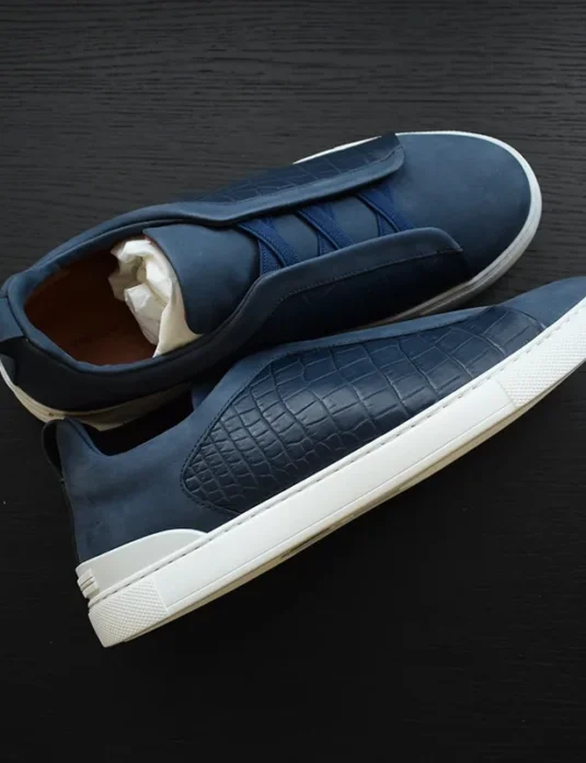Blue crocodile leather sneakers with quilted texture and white sole showing handcrafted construction details