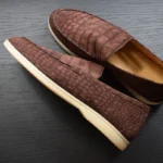 Mocassins en cuir de crocodile brun faits à la main avec une finition nubuck montrant une texture d'écailles détaillée