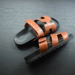 صنادل كوجناك من جلد التمساح مع نعل أسود يُظهر نسيج جلد فاخر وأشرطة قابلة للتعديل