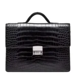 حقيبة جلدية سوداء من جلد التمساح بنقشة متقشرة وقفل برقم سري على خلفية بيضاء