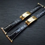 Black crocodile apple watch band with gold-plated clasp showing textured reptilian scales