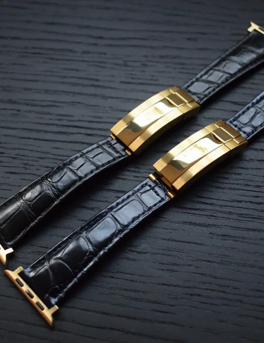 Black crocodile apple watch band with gold-plated clasp showing textured reptilian scales