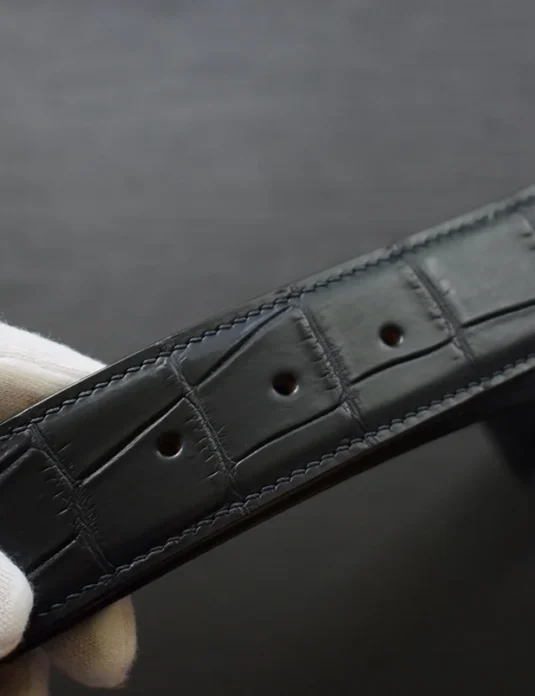黑色鳄鱼皮腰带，饰有独特的矩形鳞片纹路和手工缝线细节。