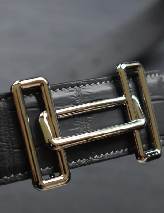 Black crocodile leather belt with gold H-style buckle showing distinctive rectangular scale pattern