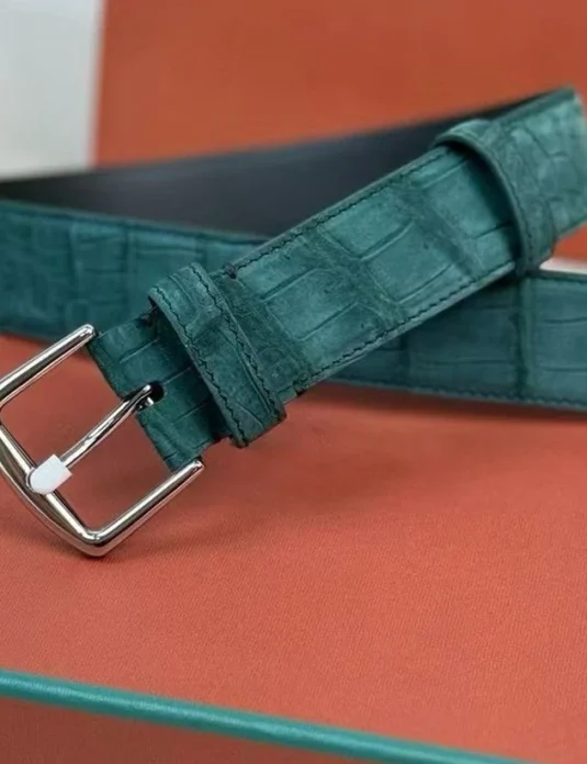 حزام تمساح أخضر من الجلد مع إبزيم فضي يعرض قشور نوبك ذات نسيج على صندوق فاخر برتقالي