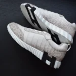 حذاء رياضي أبيض من جلد تمساح يُظهر تفاصيل نسيج جلد تمساح هيمالايا على نعل فاخر مرتدٍ