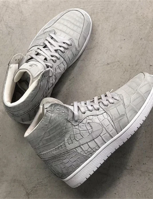 Gray crocodile leather sneakers in Jordan style showing detailed scale texture and white accents