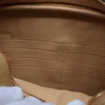 Intérieur de la pochette crocodile cognac clair montrant les emplacements de cartes et le compartiment à fermeture éclair dorée