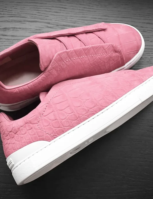 Pink crocodile sneakers in nubuck leather with distinctive scale pattern and white sole