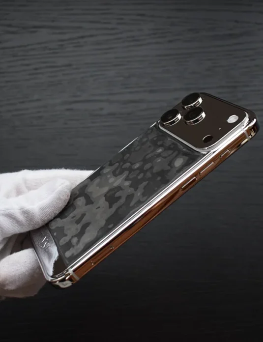 Platinum carbon iphone 17 pro max with lunar textured surface held in white gloved hands