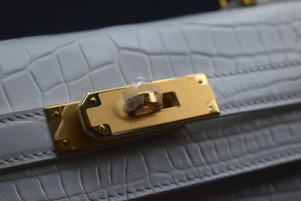 white crocodile kelly handbag close logo